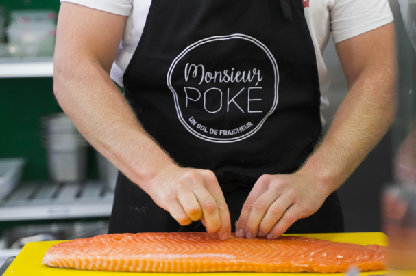Monsieur Poké entrain de cuisiner un saumon dans son restaurant à Pamiers
